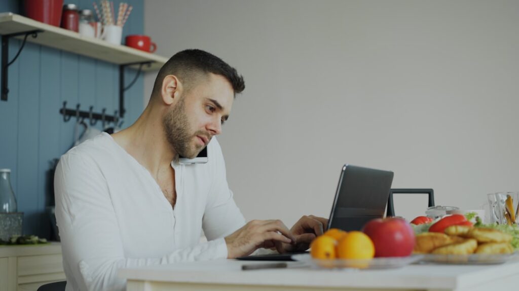 Professional real estate agent stands in a bright, modern kitchen, using a tablet to showcase the power of high-tech digit...
